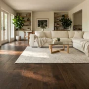 Dark wood flooring in a bright living room with a cream sofa and rug
