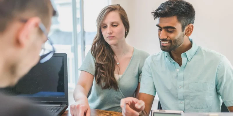 Building a Strong Foundation: Why Engaged Couples Should Talk to a Professional First Engaged couple reviewing their finances with a financial advisor at a desk
