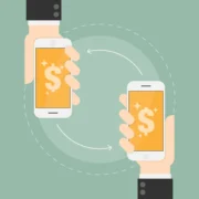 Two hands holding smartphones that send money to each other