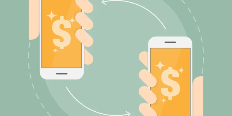 Two hands holding smartphones that send money to each other