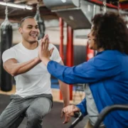 Personal trainer giving a high five to a client during a gym workout